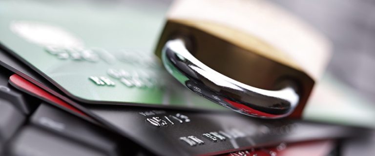 closeup of a padlock laying on top of debit cards to indicate security when using