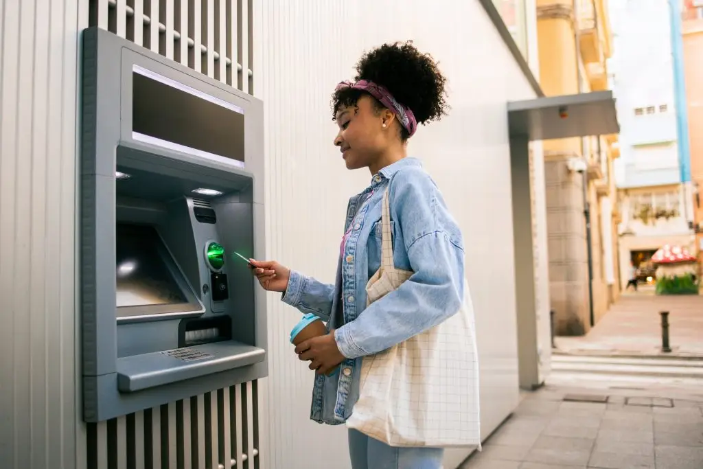 A woman making a withdrawal from her checking account at an ATM
